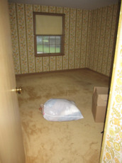 Bedroom with old carpet over hardwood floors